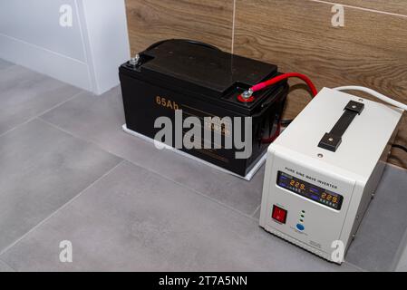 Alimentazione di emergenza con batteria da 12 V 65 Ah che fornisce una tensione alternata sinusoidale pura ininterrotta di 230 Volt. Foto Stock