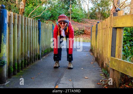 Allenati con una donna anziana attiva con oltre 60 esercizi il giorno d'autunno a Hermitage Park, Helensburgh, Argyll e Bute, Scozia Foto Stock