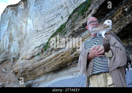 Allevatore di rapaci tedesco con gufo fienile per scattare foto sulla costa di Etretat, la "pointe de la Courtine" sulla spiaggia "plage d'Antifer" vicino a Till Foto Stock