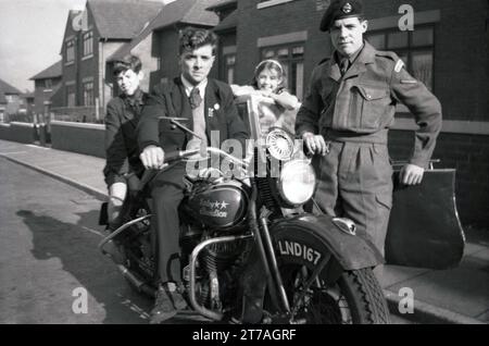 Anni '1950, storico, giovane su una moto Harley Davidson + sidecar dell'epoca, probabilmente di proprietà di un militare che si trovava accanto a lui, Inghilterra, Regno Unito. Un ragazzo più giovane si siede dietro di lui e una ragazza sta in sidecar Foto Stock