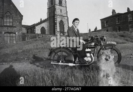 1950, storico, giovane con berretto seduto su una moto Sunbeam dell'epoca, Oldham, Manchester, Inghilterra, Regno Unito. Cucciolo accanto. Sunbeam Cycles, un marchio britannico di biciclette prodotto per la prima volta nel 1887 da John Marston, che nel 1912 iniziò a produrre motociclette a Woverhampton, che continuò lì fino al 1937, fino a quando il marchio fu venduto alla Associated Motor Cycles (AMC). Nel 1943 AMC vendette il nome Sunbeam alla più grande società BSA, che continuò la produzione di motociclette fino al 1956, fino a quando le basse vendite continuarono a cessare la produzione. Foto Stock