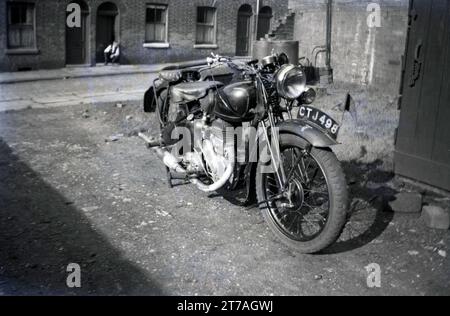 1950, storica, una moto Sunbeam dell'epoca parcheggiata in un'area di ghiaia aperta accanto a una strada secondaria a Oldham, Manchester, Inghilterra, Regno Unito. Sunbeam Cycles, un marchio britannico di biciclette prodotto per la prima volta nel 1887 da John Marston, che nel 1912 iniziò a produrre motociclette a Woverhampton, che continuò lì fino al 1937, fino a quando il marchio fu venduto alla Associated Motor Cycles (AMC). Nel 1943 AMC vendette il nome Sunbeam alla più grande società BSA, che continuò la produzione di motociclette fino al 1956, fino a quando le basse vendite continuarono a cessare la produzione. Foto Stock