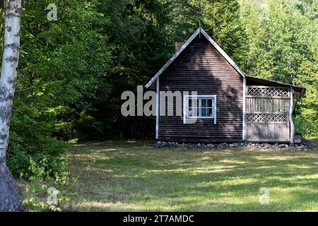 Tradizionale casa in legno sulla penisola di Juminda nella contea di Harju in una soleggiata giornata estiva, circondata da forrest, Mar Baltico, Estonia Foto Stock