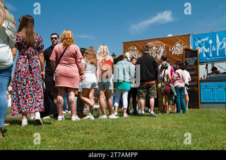 Una lunga fila di persone che aspettano di essere servite in Uno stand di fast food al Christchurch Food Festival, Christchurch UK Foto Stock
