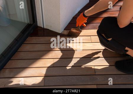 Pannelli di legno IPE verniciatura con olio protettivo, concetto di manutenzione della casa Foto Stock