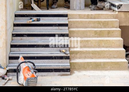 Passi concreti in costruzione come un team di costruttori installare blocchi di cemento pesanti Foto Stock