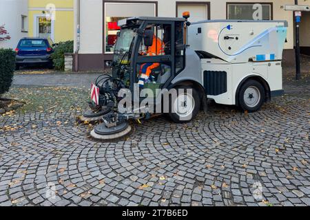 Una spazzatrice stradale che pulisce i marciapiedi pavimentati. Strada cittadina. Foto Stock
