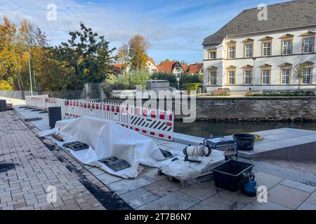 Cantiere con un percorso pavimentato di recente recintato con barriere in plastica. Costruire e alberi sullo sfondo. Foto Stock