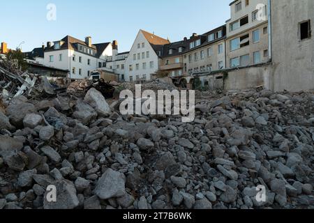 Rovine in cemento di una casa demolita e di edifici residenziali sullo sfondo. Cielo azzurro. Foto Stock