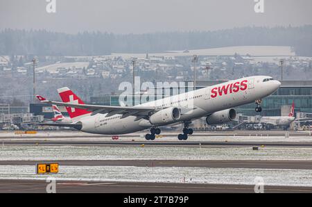 Swiss International Airlines Ein Airbus A340-313X von Swiss International Airlines startet von Startbahn 16 des sich in winterlicher Landschaft befindlichen Flughafen Zürich. Registratin HB-JHM. Zürich, Schweiz, 18.12.2022 *** Swiss International Airlines un Airbus A340 313X di Swiss International Airlines decolla dalla pista 16 dell'aeroporto di Zurigo Registratin HB JHM Zurigo, Svizzera, 18 12 2022 in un paesaggio da sogno credito: Imago/Alamy Live News Foto Stock