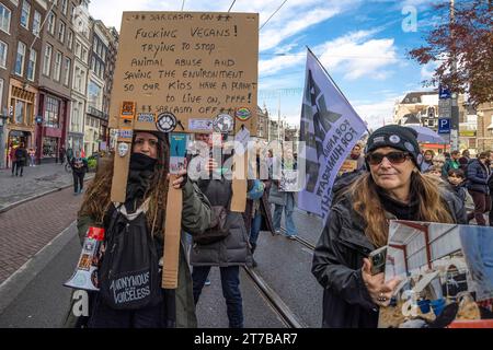 Amsterdam, Paesi Bassi. 12 novembre 2023. Un manifestante tiene un cartello che esprime la sua opinione durante la manifestazione. Si stima che 85.000 manifestanti abbiano partecipato a una marcia pacifica sul clima senza arresti. Questo ha superato la dimostrazione climatica di due anni fa, che ha avuto 45.000 partecipanti. I dimostranti hanno percorso un percorso da Piazza Dam al Museumplein. Sulla loro strada si unirono a una grande marcia filo-palestinese. Tra i manifestanti c'era l'attivista per il clima svedese Greta Thunberg, in seguito tenne un breve discorso sul Museumplein. La marcia è stata organizzata da nove organizzazioni, sotto il nome Foto Stock