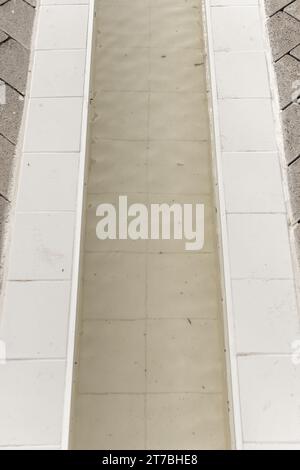 Un piccolo canale piastrellato con un flusso d'acqua Foto Stock