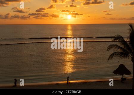 Vista dall'alto dell'alba sul Golfo del Messico con i lavoratori che puliscono la spiaggia sulla Riviera Maya Foto Stock