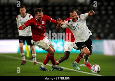 Kane Wilson (destra) della contea di Derby battaglie del pallone con Lewis Billington di Crewe Alexandra (sinistra) e Aaron Rowe (dietro) durante la partita di replay del primo turno della Emirates fa Cup a Pride Park, Derby. Data immagine: Martedì 14 novembre 2023. Foto Stock