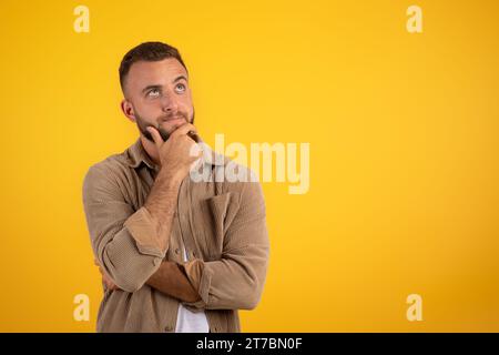 Focalizzato pensivo giovane uomo caucasico con la barba nei pensieri casuali Foto Stock