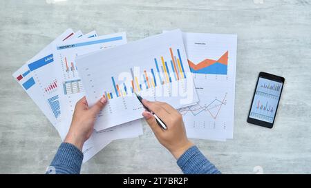 Un uomo d'affari che controlla ha riportato dei profitti sulla carta. Documentazione cartacea e concetto finanziario. Primo piano Foto Stock