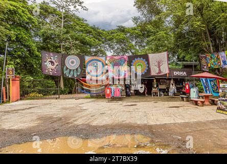 Costa Rica, Luganillas - 22 luglio 2023: Attività commerciali sul fiume Tarcoles e sul ponte dei coccodrilli. Negozio di souvenir, Doka. Linea di coloratissimi tex a tema indiano Foto Stock