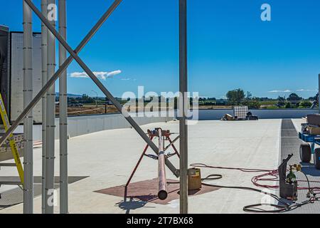 Una lunghezza di tubo di rame da preparare per la brasatura sul tetto di un magazzino di stoccaggio a freddo (refrigerazione industriale) a CO2. Foto Stock