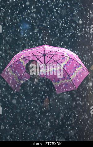 Giacarta, Indonesia. 14 novembre 2023. Un uomo che tiene un ombrello cammina sotto la pioggia a Giacarta, Indonesia, il 14 novembre 2023. Credito: Agung Kuncahya B./Xinhua/Alamy Live News Foto Stock