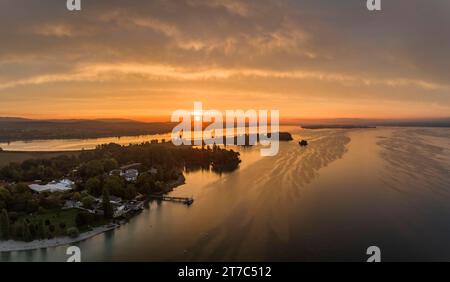 Panorama aereo del Lago di Costanza occidentale all'alba con la penisola di Mettnau, con spiaggia balneabile, pontile e ristorante Strandcafè, sul Foto Stock