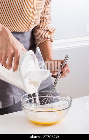 Chiudere la mano della donna aggiungendo la ciotola della farina Foto Stock