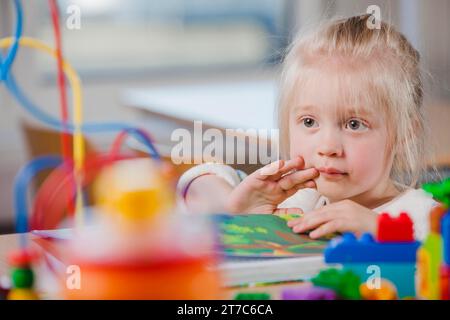 Carina bambina in età prescolare che guarda lontano Foto Stock