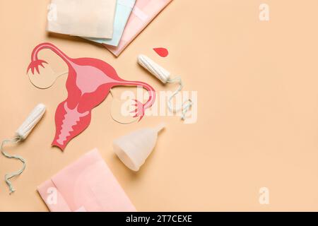Composizione con utero di carta e diversi prodotti per l'igiene femminile su sfondo colorato Foto Stock