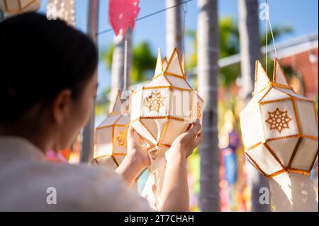 Una bella e felice donna thailandese-asiatica appende una lanterna di carta e si gode il festival YI Peng o Loy Krathong in un tempio di Chiang mai. Thai-Lanna Foto Stock