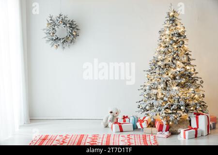 Albero di natale bianco ricoperto di neve decorato con giocattoli e regali per l'anno nuovo Foto Stock