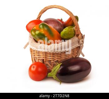 Un cestino di verdure appena raccolte, tra cui pomodori, peperoni e melanzane Foto Stock