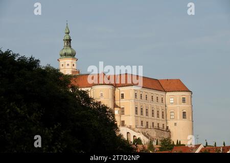 Castello di Mikulov, vista da ovest. Il castello è parzialmente nascosto dietro le cime degli alberi. Il castello di Mikulov si trova nella regione della Moravia meridionale Foto Stock