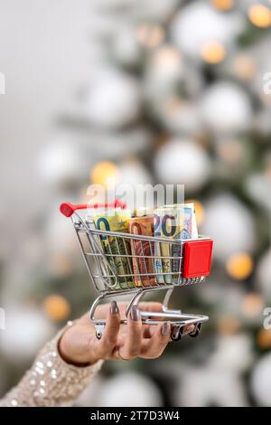 Soldi per lo shopping natalizio all'interno del piccolo tram tenuto da una mano femminile. Foto Stock