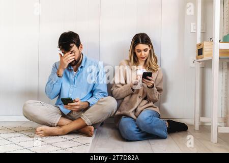 Dipendenza gadget e problemi di relazione. Coppia con gli smartphone che si ignorano l'un l'altro Foto Stock