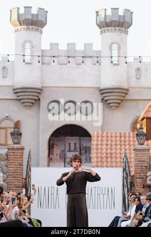 Un uomo maturo che indossa un abito grigio acuto si trova di fronte a un grande castello in stile europeo Foto Stock