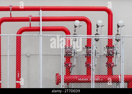 Allarme sprinkler linea di tubazioni di alimentazione dell'acqua ad alta pressione con valvola di controllo nell'edificio industriale dell'area recinzione di sicurezza Foto Stock