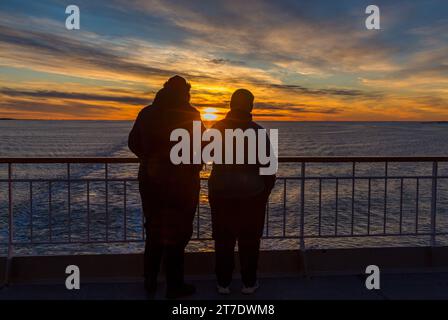 Tramonto mozzafiato sul Mare di Norvegia a nord di Trondheim, i passeggeri Hurtigruten guardano il sole tramontare in Norvegia, Scandinavia, Europa in ottobre Foto Stock