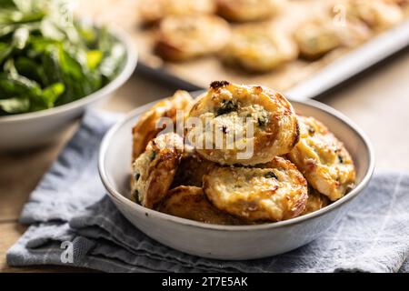 Mini panini per pizza ripieni di vari ingredienti, prosciutto pancetta spinaci, basilico, mozzarella o parmigiano in ciotola. Foto Stock