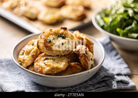 Mini panini per pizza ripieni di vari ingredienti, prosciutto pancetta spinaci, basilico, mozzarella o parmigiano in ciotola. Foto Stock