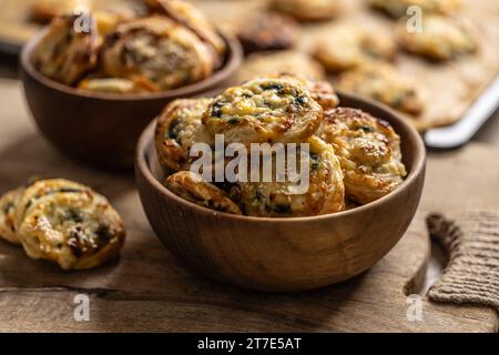 Mini panini per pizza ripieni di vari ingredienti, prosciutto pancetta spinaci, basilico, mozzarella o parmigiano in una ciotola di legno. Foto Stock