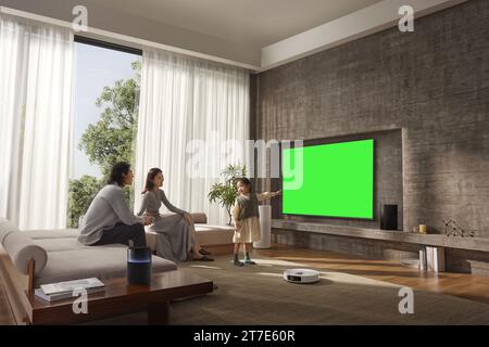 Le persone guardano e si divertono accanto al televisore, monitor con schermo verde Foto Stock