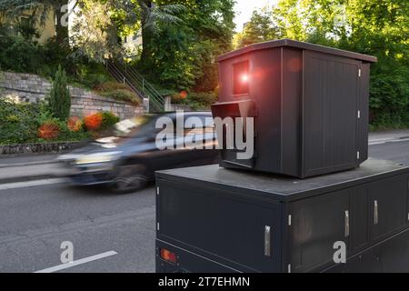 Autovelox portatile sul lato della strada che cattura un'auto in movimento, in un'area residenziale Foto Stock