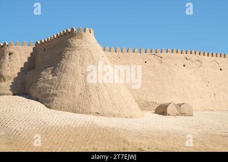 Frammento di un antico muro difensivo con una torre in una giornata di sole. Centro di Ichan-Kala. Khiva, Uzbekistan Foto Stock