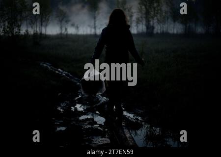 La ragazza cammina nella nebbia al mattino. Riposa in natura. Nebbia nella palude. L'uomo porta le cose all'acqua. Foto Stock