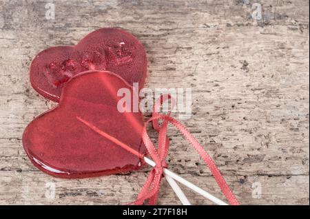 caramelle rosse a forma di cuore su tavolo in legno con spazio per fotocopie Foto Stock