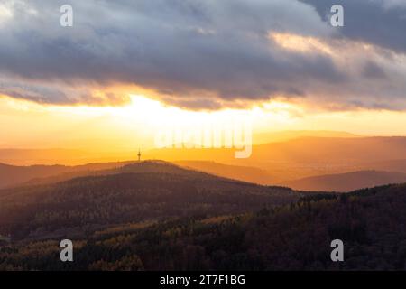 Abendstimmung im Taunus Von den Höhenlagen des Taunus aus gesehen scheint die Abendsonne und Wolken hindurch auf die Ausläufer des Taunus und den Atzelberg mit dem Sendemast. BEI Wind sowie einem Wechsel von Regen und Sonne zeigte sich das Wetter heute durchwachsen., Königstein Hessen Deutschland *** Evening mood nel Taunus visto dalle alture del Taunus, il sole e le nuvole serali brillano sulle colline pedemontane del Taunus e dell'Atzelberg con l'albero di trasmissione con il vento e un alternarsi di pioggia e sole, il tempo oggi è stato misto, Königstein Assia Germania Foto Stock