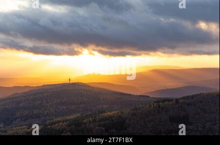 Abendstimmung im Taunus Von den Höhenlagen des Taunus aus gesehen scheint die Abendsonne und Wolken hindurch auf die Ausläufer des Taunus und den Atzelberg mit dem Sendemast. BEI Wind sowie einem Wechsel von Regen und Sonne zeigte sich das Wetter heute durchwachsen., Königstein Hessen Deutschland *** Evening mood nel Taunus visto dalle alture del Taunus, il sole e le nuvole serali brillano sulle colline pedemontane del Taunus e dell'Atzelberg con l'albero di trasmissione con il vento e un alternarsi di pioggia e sole, il tempo oggi è stato misto, Königstein Assia Germania Foto Stock