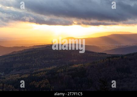 Abendstimmung im Taunus Von den Höhenlagen des Taunus aus gesehen scheint die Abendsonne und Wolken hindurch auf die Ausläufer des Taunus und den Atzelberg mit dem Sendemast. BEI Wind sowie einem Wechsel von Regen und Sonne zeigte sich das Wetter heute durchwachsen., Königstein Hessen Deutschland *** Evening mood nel Taunus visto dalle alture del Taunus, il sole e le nuvole serali brillano sulle colline pedemontane del Taunus e dell'Atzelberg con l'albero di trasmissione con il vento e un alternarsi di pioggia e sole, il tempo oggi è stato misto, Königstein Assia Germania Foto Stock