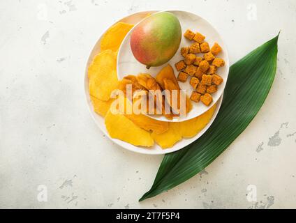 Piatti con fette di mango dolce essiccate e palline con mango succoso fresco e foglia verde. Foto Stock