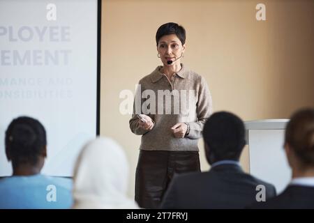 Una posizione professionale sicura di fronte al pubblico durante la presentazione dei principi di impiego e la spiegazione di uno dei punti Foto Stock