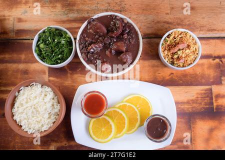 Feijoada tipica cucina brasiliana, fagioli con pancetta di maiale, riso all'arancia e farina, salsa al peperoncino e crackling Foto Stock